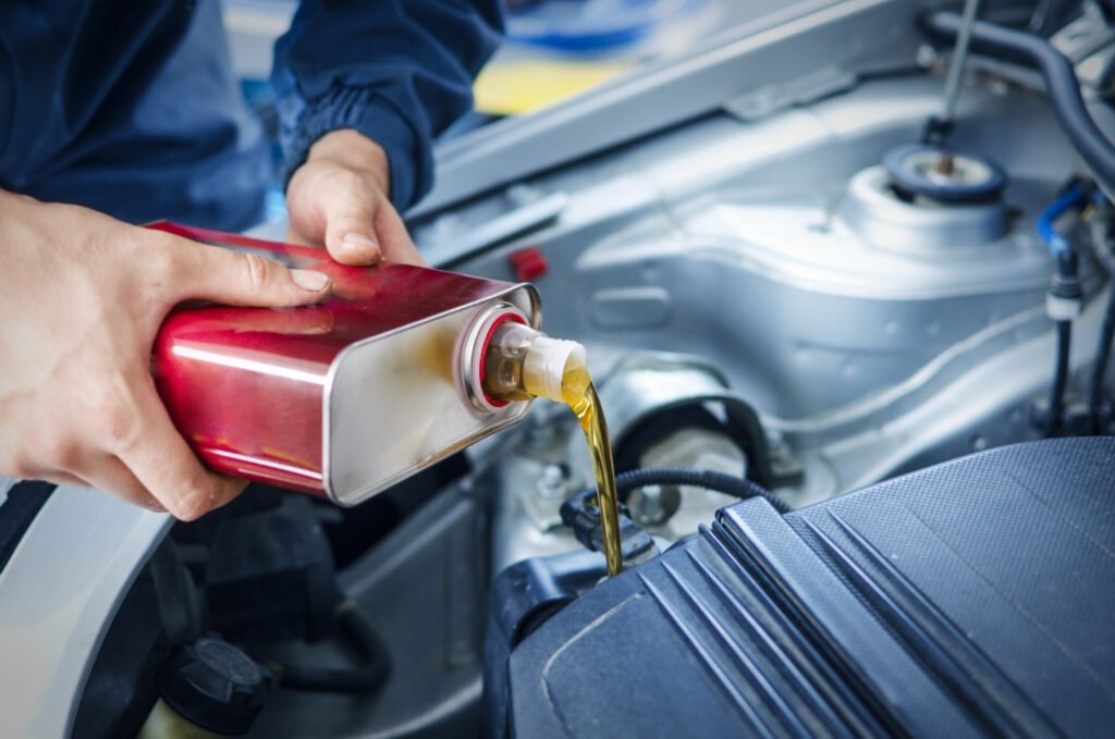 understanding the viscosity classification system: mechanic changing oil in a car